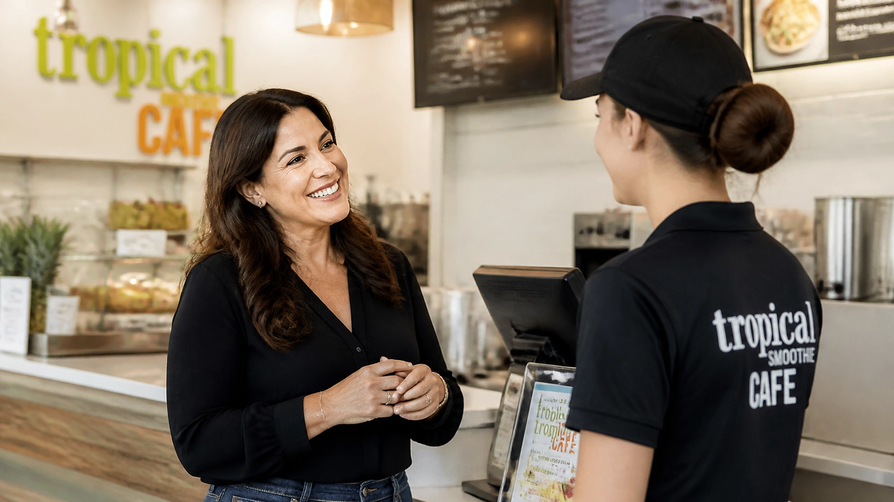 A franchise owner and employee interacting warmly in a modern restaurant setting