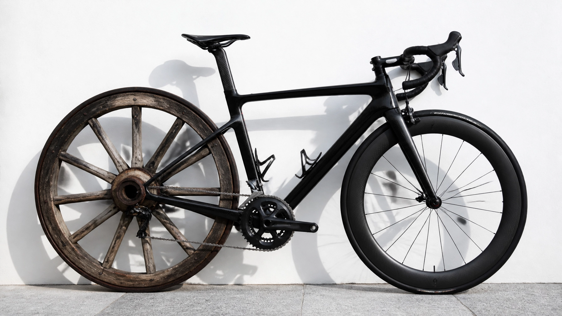 A bicycle with a modern racing wheel in front and an old wooden wagon wheel in the back.